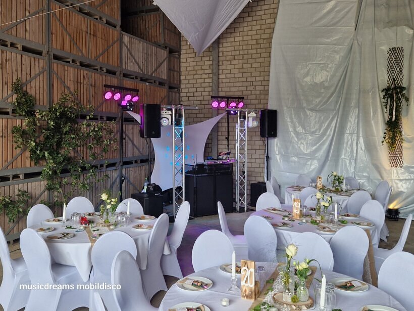 Professioneller DJ-Aufbau auf einer Hochzeit auf einem Bauernhof – rustikale Atmosphäre mit Licht, Ton und stimmungsvoller Musik für eine unvergessliche Feier.
