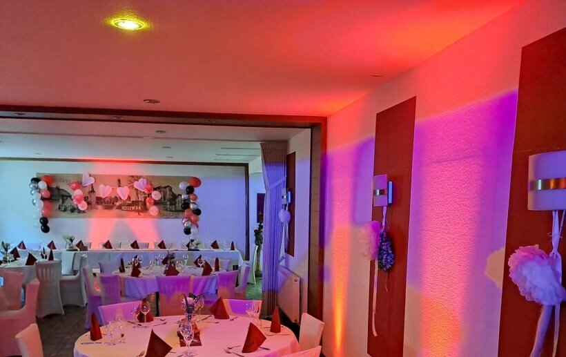 Professioneller DJ-Aufbau in einem Festsaal – stilvolle Beleuchtung, hochwertige Soundanlage und perfekte Atmosphäre für Hochzeiten und Events.