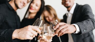 Begeisterte Mitarbeiter feiern ausgelassen mit einem professionellen DJ für Firmenfeiern auf einer erfolgreichen Firmenveranstaltung