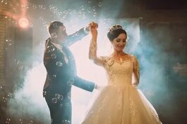 Brautpaar tanzt einen romantischen Hochzeitstanz Discofox als Eröffnungstanz mit stimmungsvoller Beleuchtung und Nebeleffekten