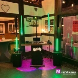 Modernes DJ-Setup in Enger mit LED-Sticks und Säulenlautsprechern für ein einzigartiges Partyerlebnis.