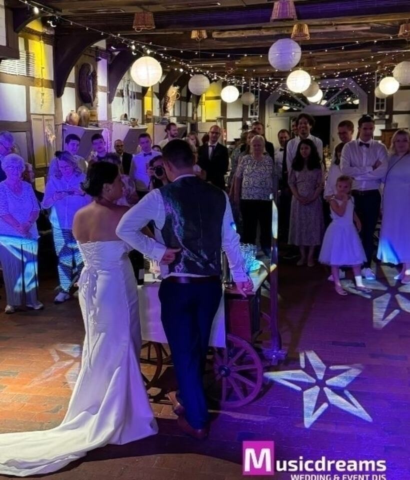 Brautpaar in Rödinghausen beim Tortenanschnitt, begleitet von stimmungsvoller Musik durch einen DJ in Rödinghausen